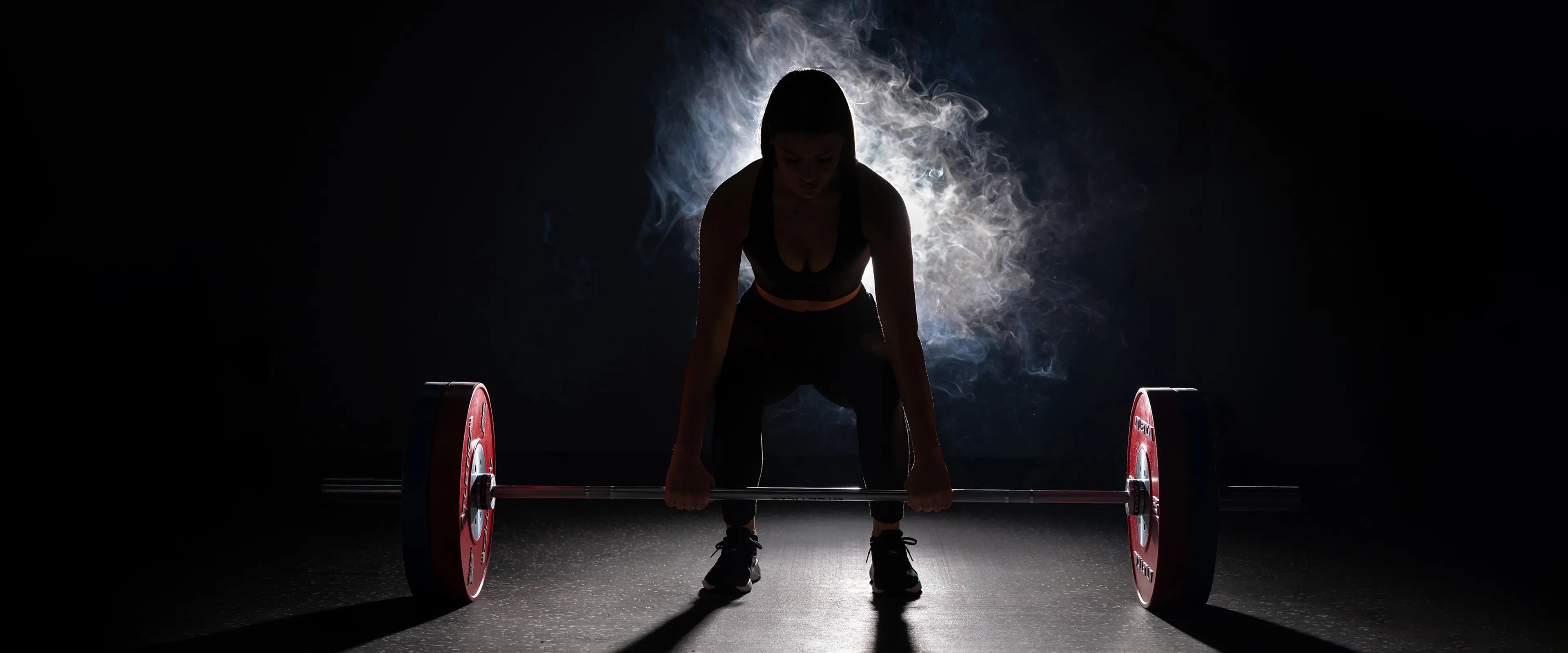 Athletin beim Kreuzheben mit Langhantel und Competition Bumper Plates Gewichten